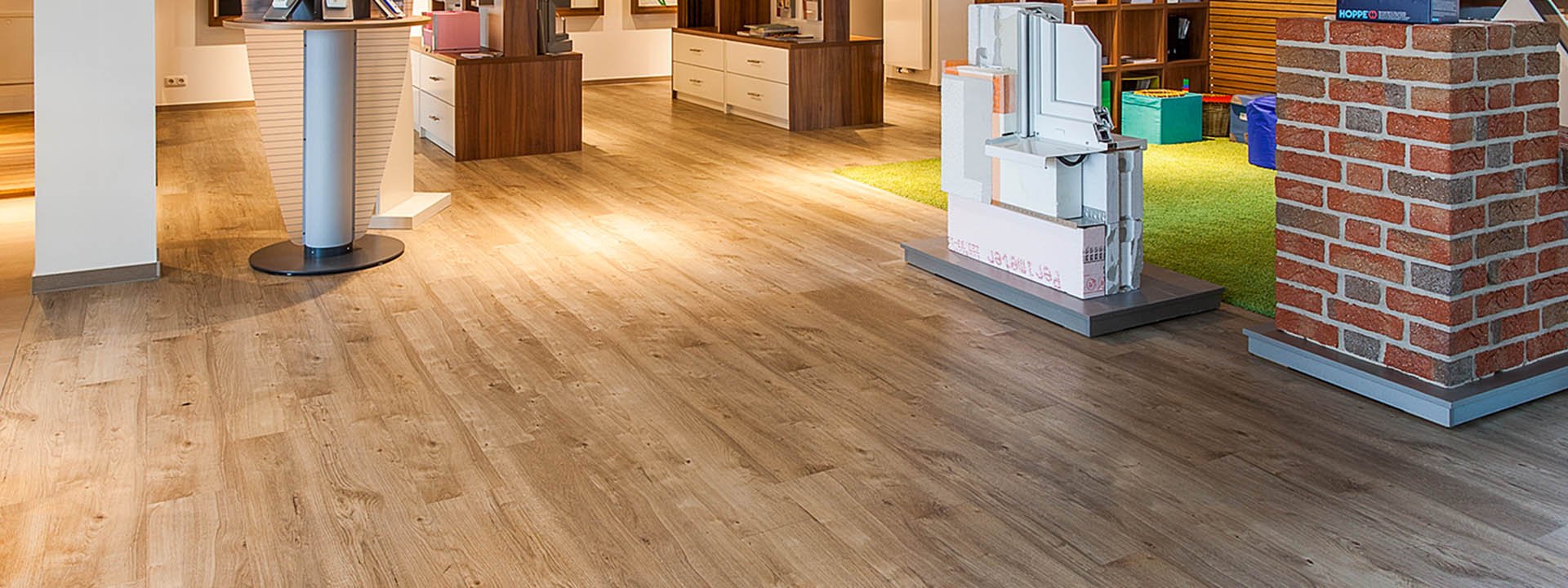 Ausstellungsraum mit hellem Holzdesignboden, Musterfl&auml;chen und verschiedenen Pr&auml;sentationsbereichen